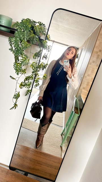 Look con sweater negro, minifalda y botas altas